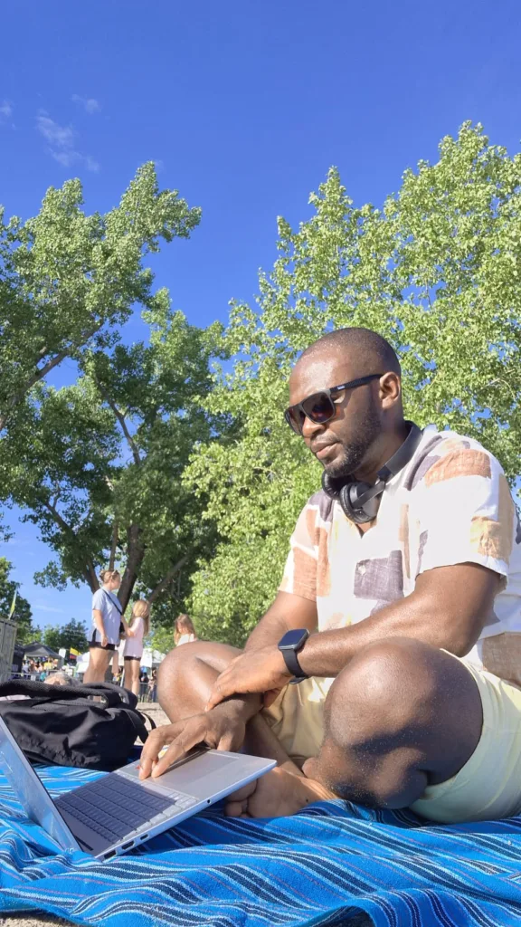 Segun Samuel, a Cornwall financial consultant, working on a laptop outdoors while building stress-free plans to help clients lower unsecured debt.